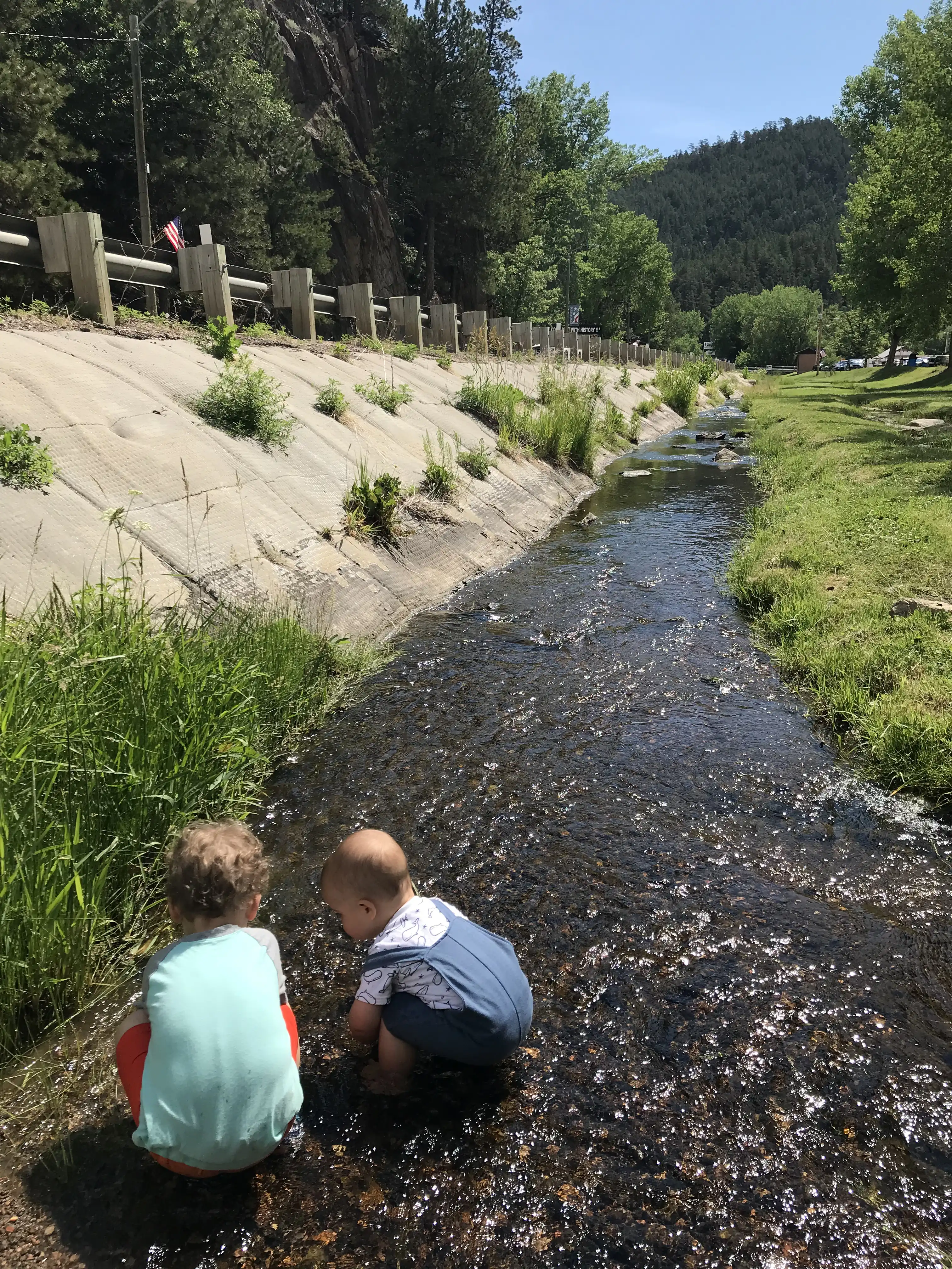 Graham and Royal playing in the creek near Hill City.