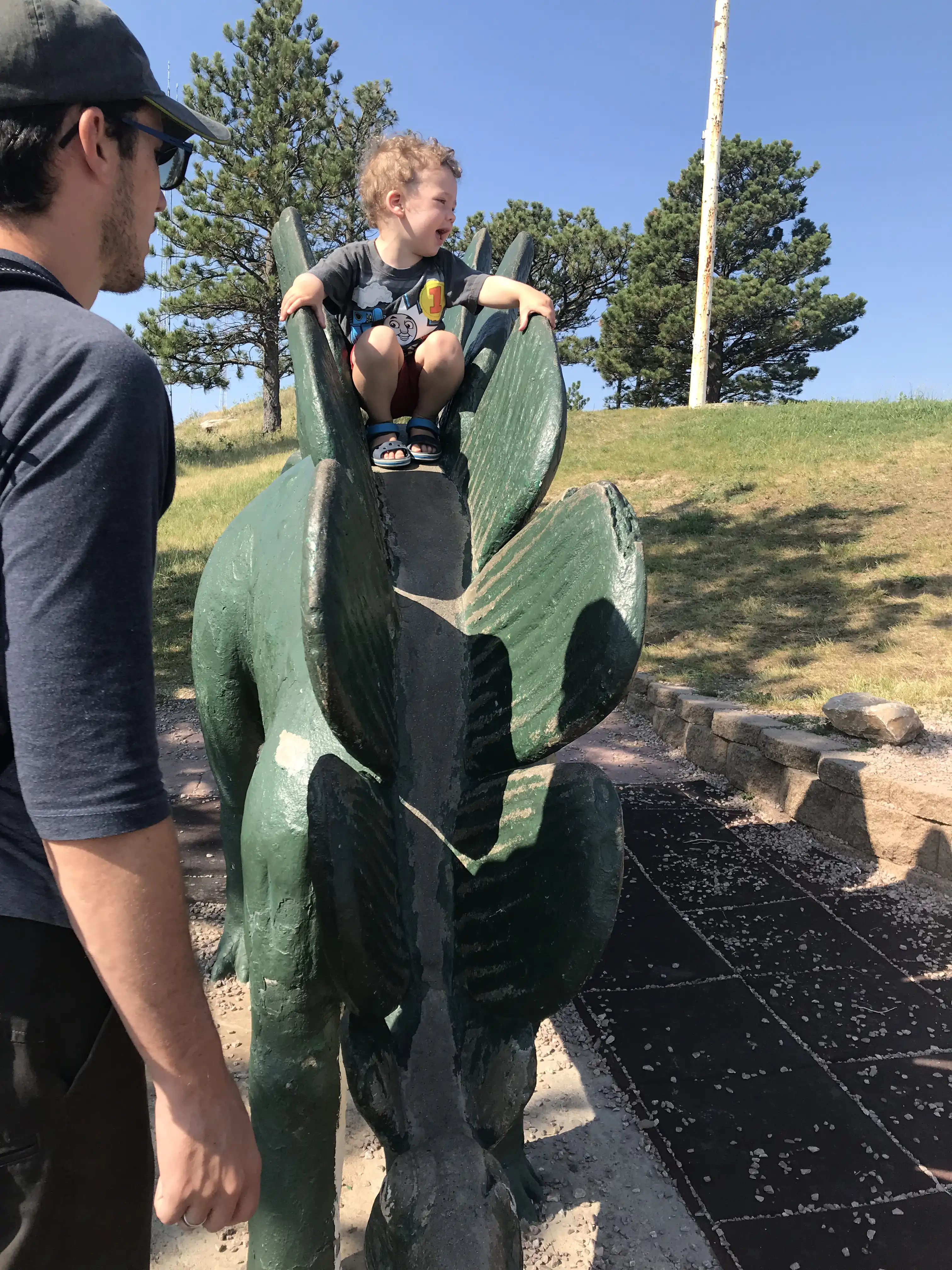 Alex with Graham on the Stegosaurus at Dinosaur Park.