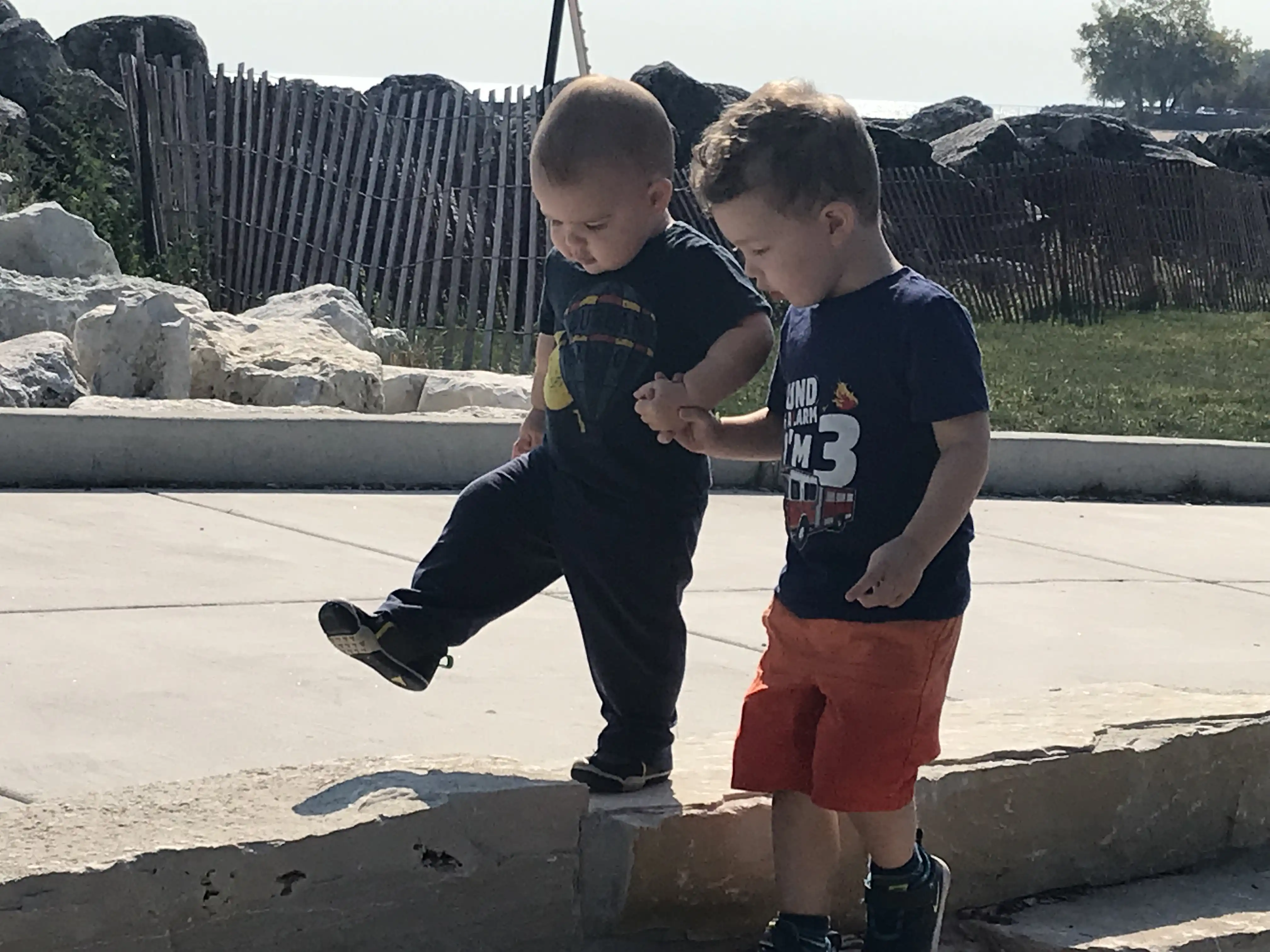 Graham and Royal holding hands walking along a concrete walkway.