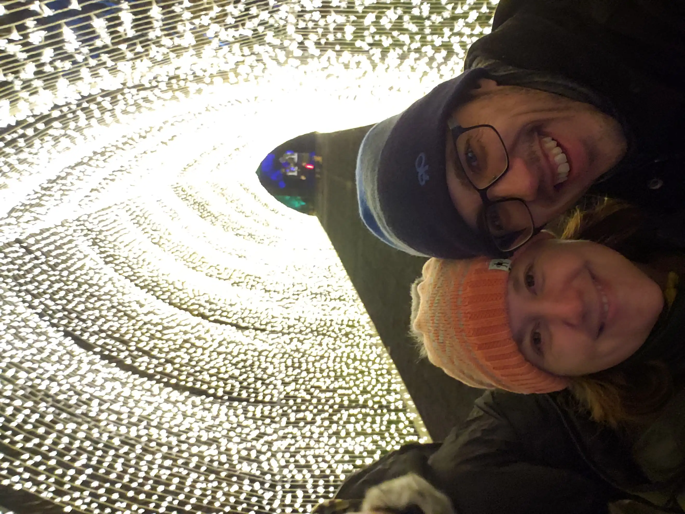 Amie and Alex below a huge arc tunnel of white lights.