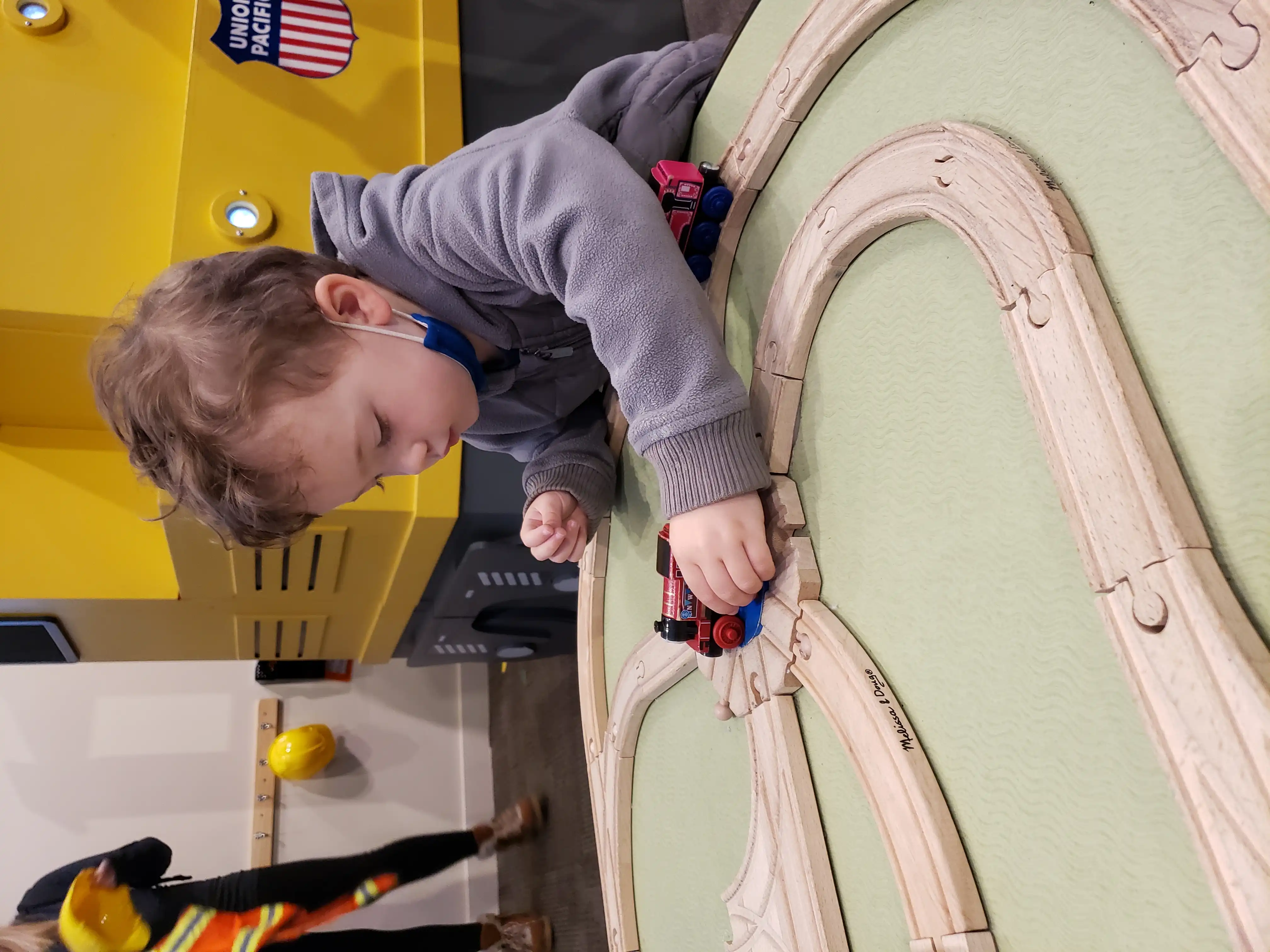 Graham playing with a wooden train set, the piece that rotates to select a new track.