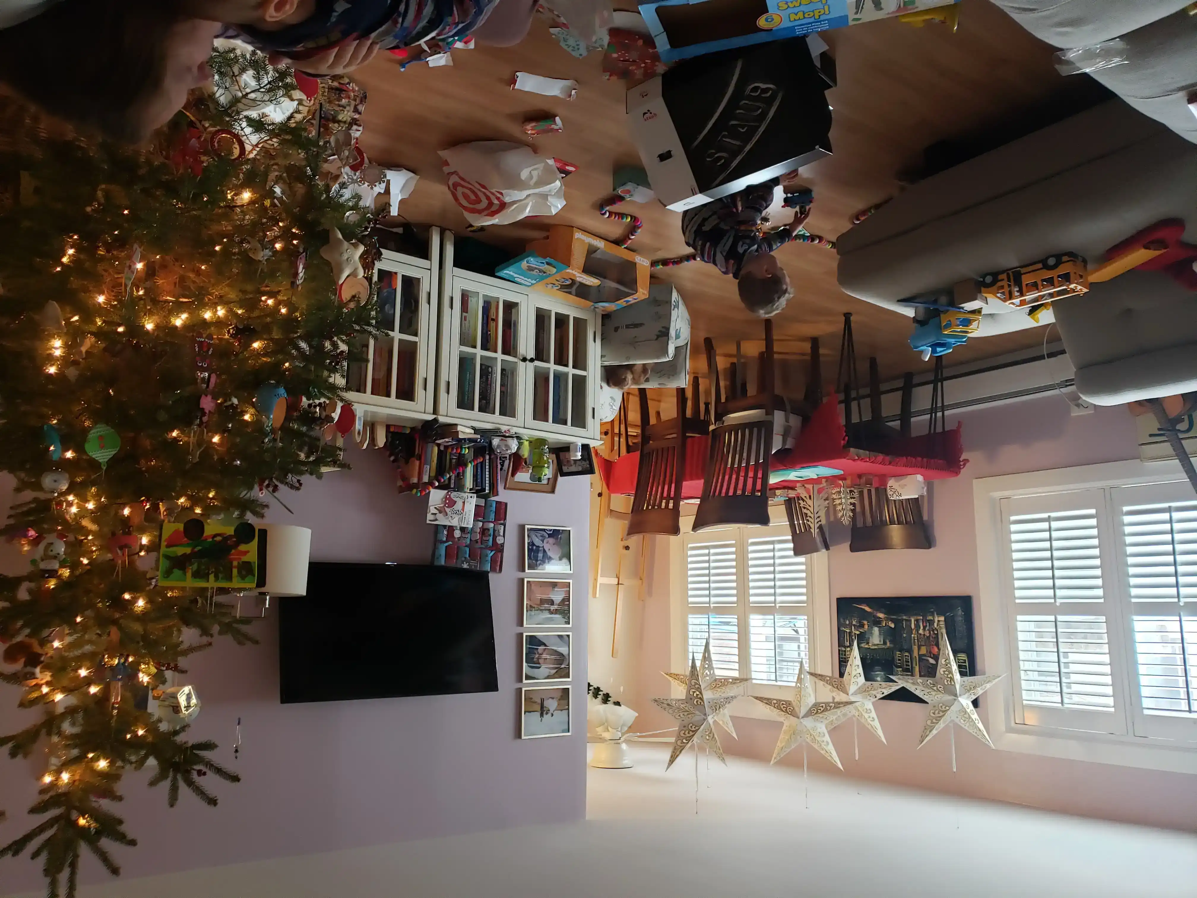 Graham playing in the living room with Christmas decorations and spent wrapping paper all around.