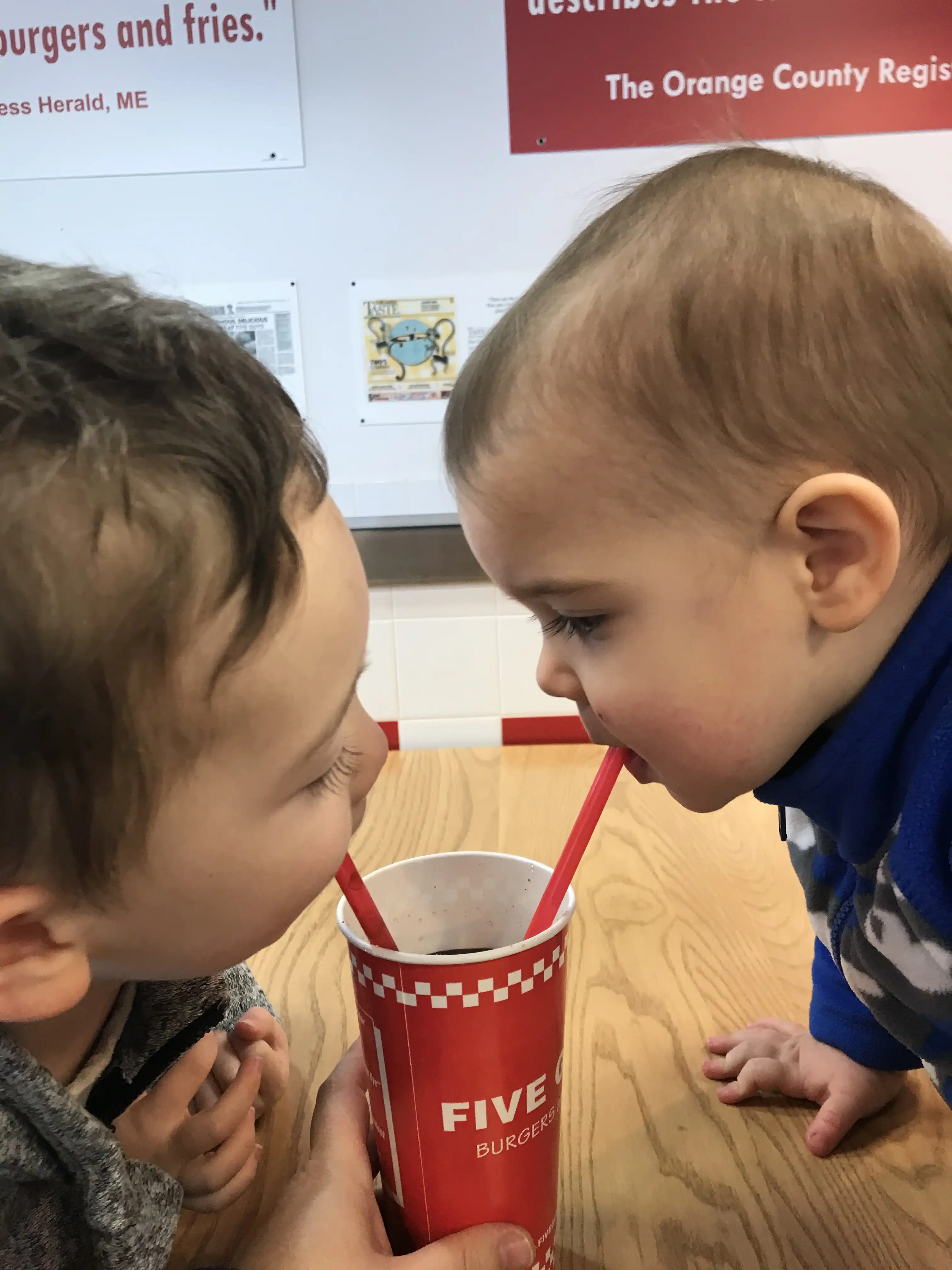 Graham and Royal drinking from the same cup.