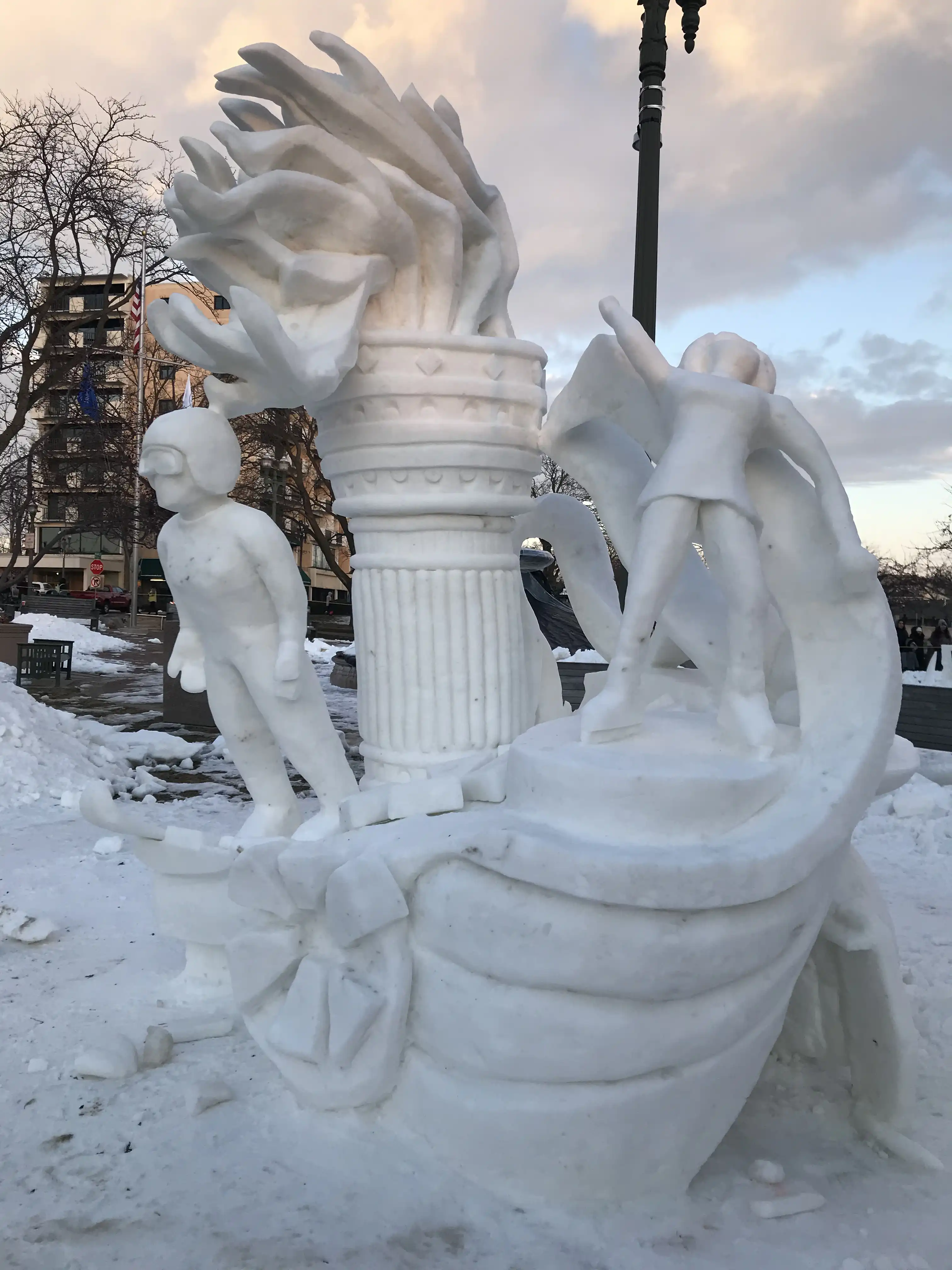 An ice sculpture featuring many of the winter olympic events, ski jump, ice skating, and the olympic flame.