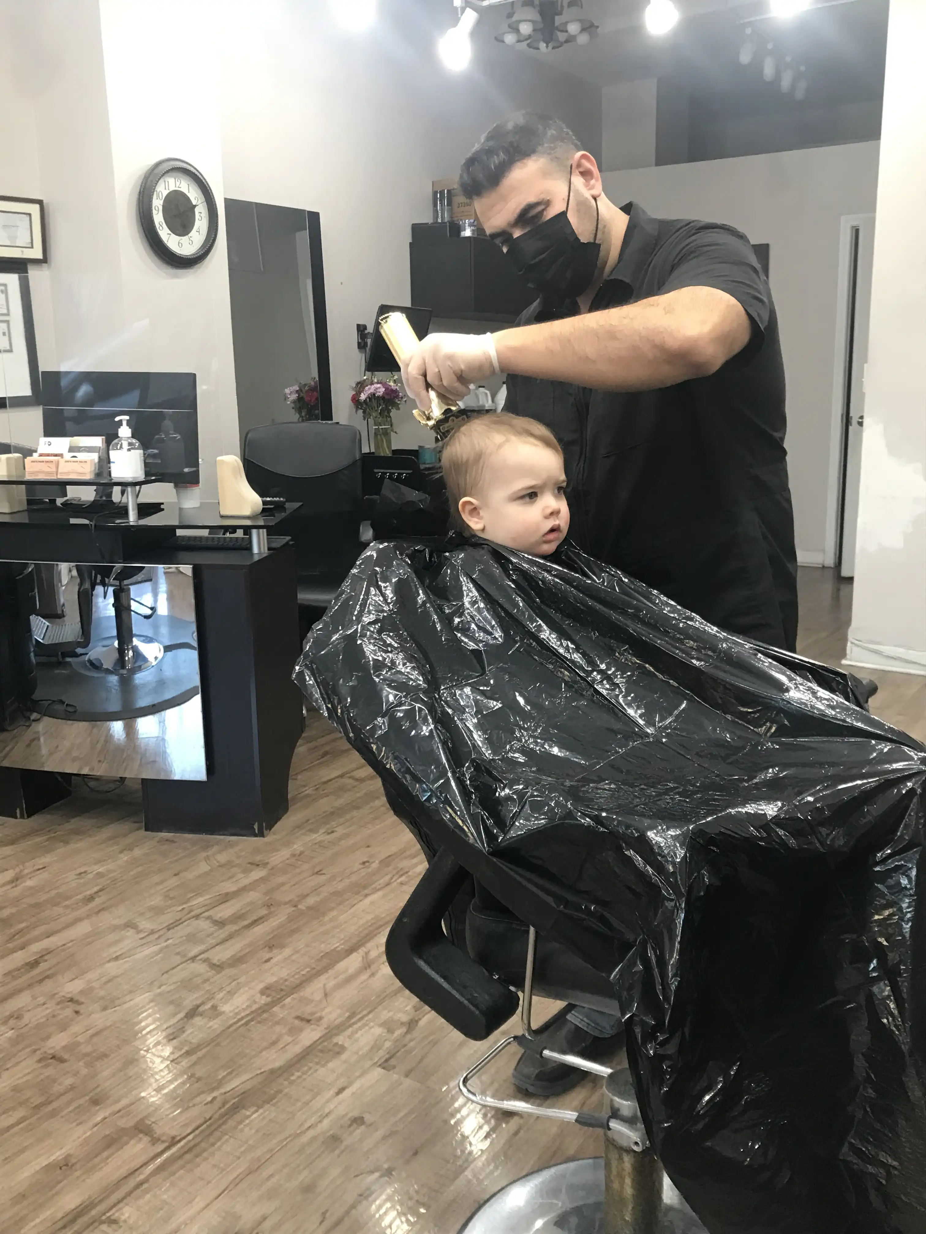 Royal in a barber chair getting his hair cut for the first time at Joe's.