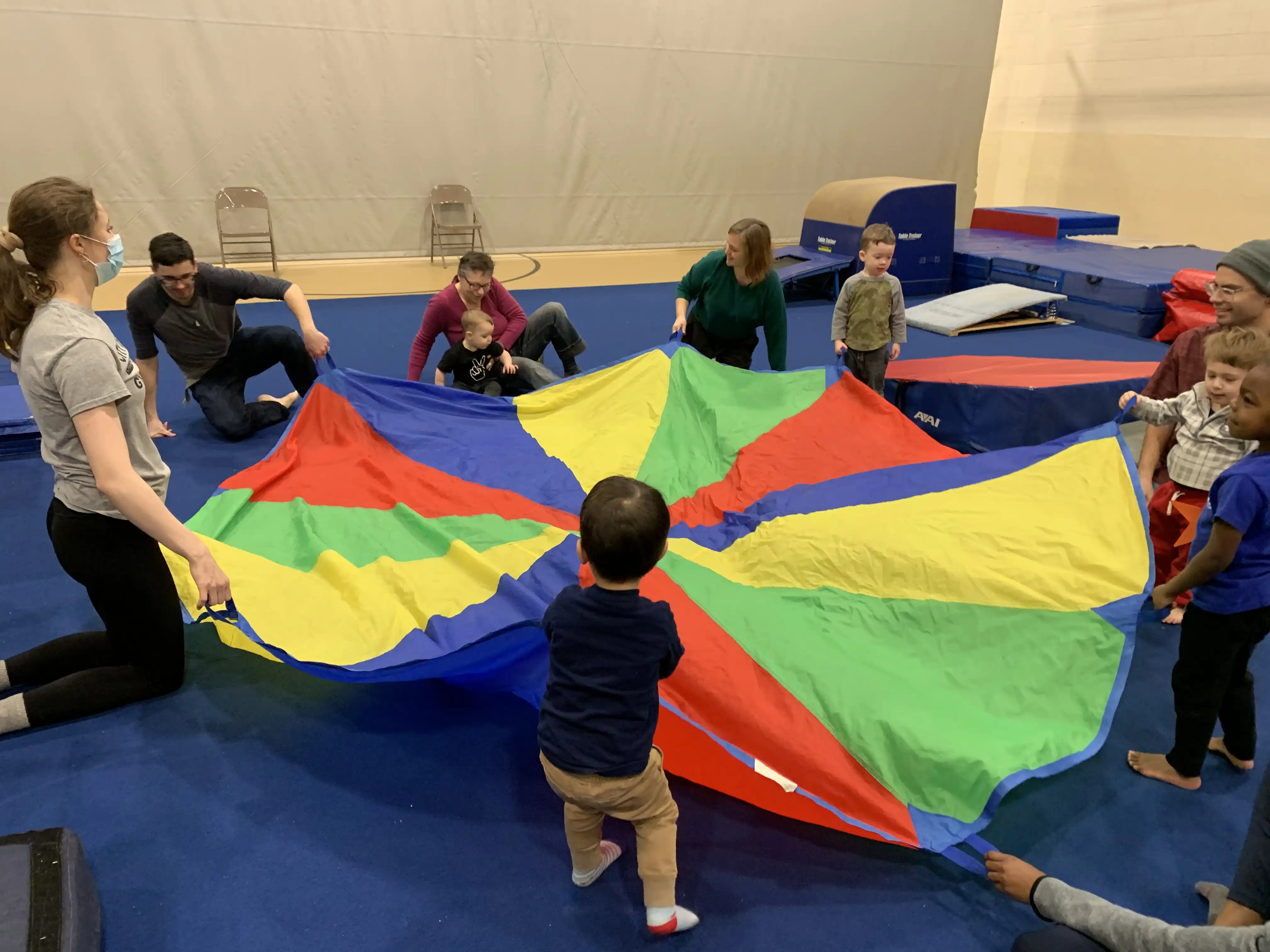 Everyone around the multi-colored parachute.
