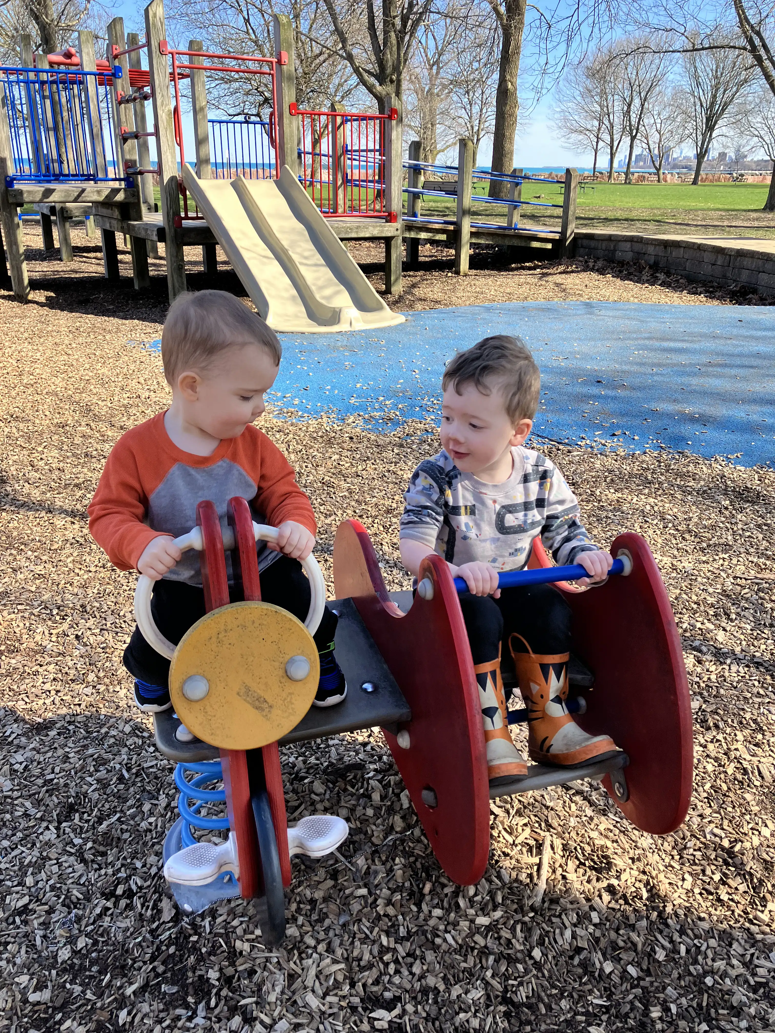 Graham and Royal riding a tilter at the park.
