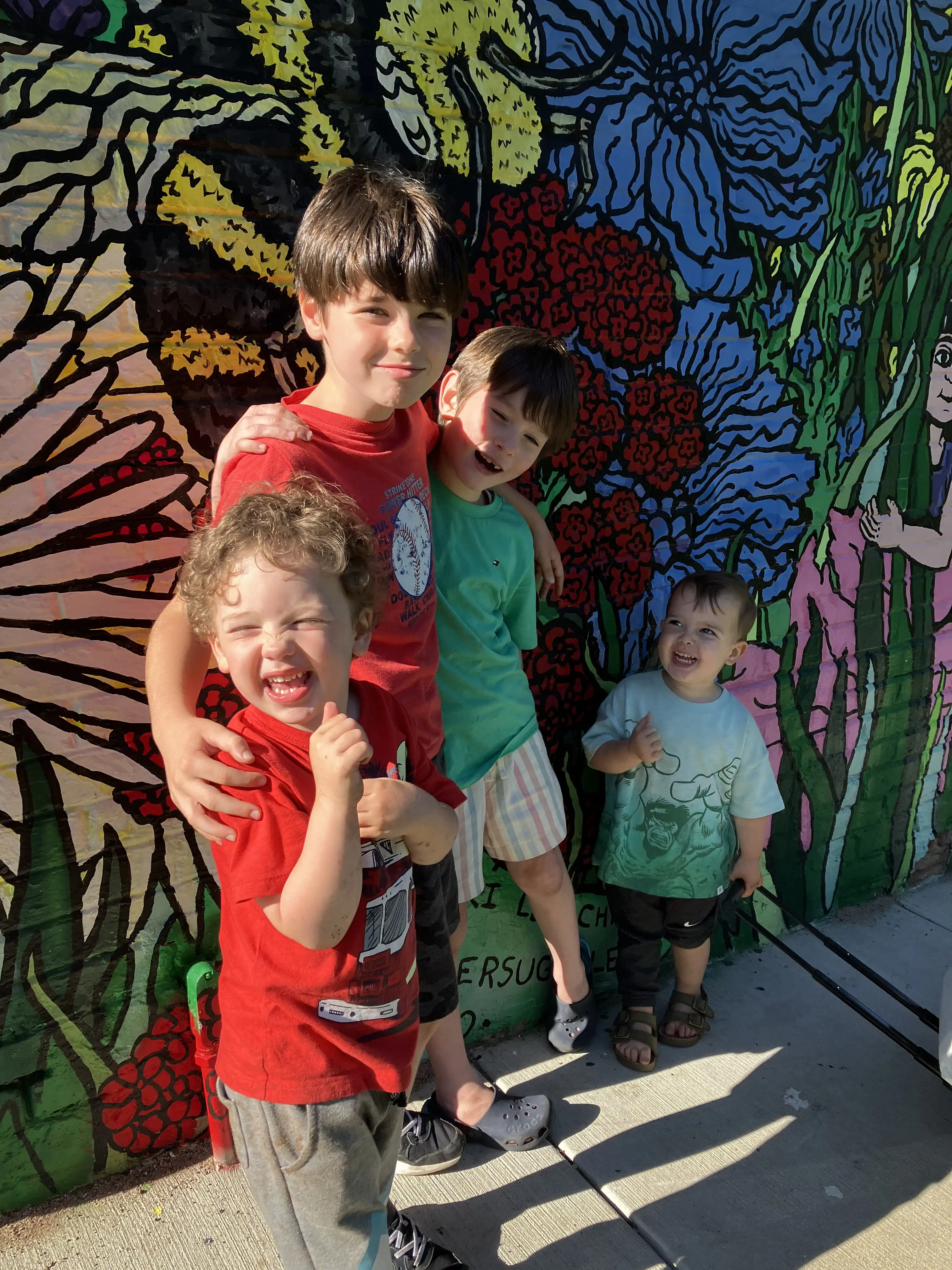 Graham, Andrea, Ammar, and Royal in front of a mural at the nearby park.