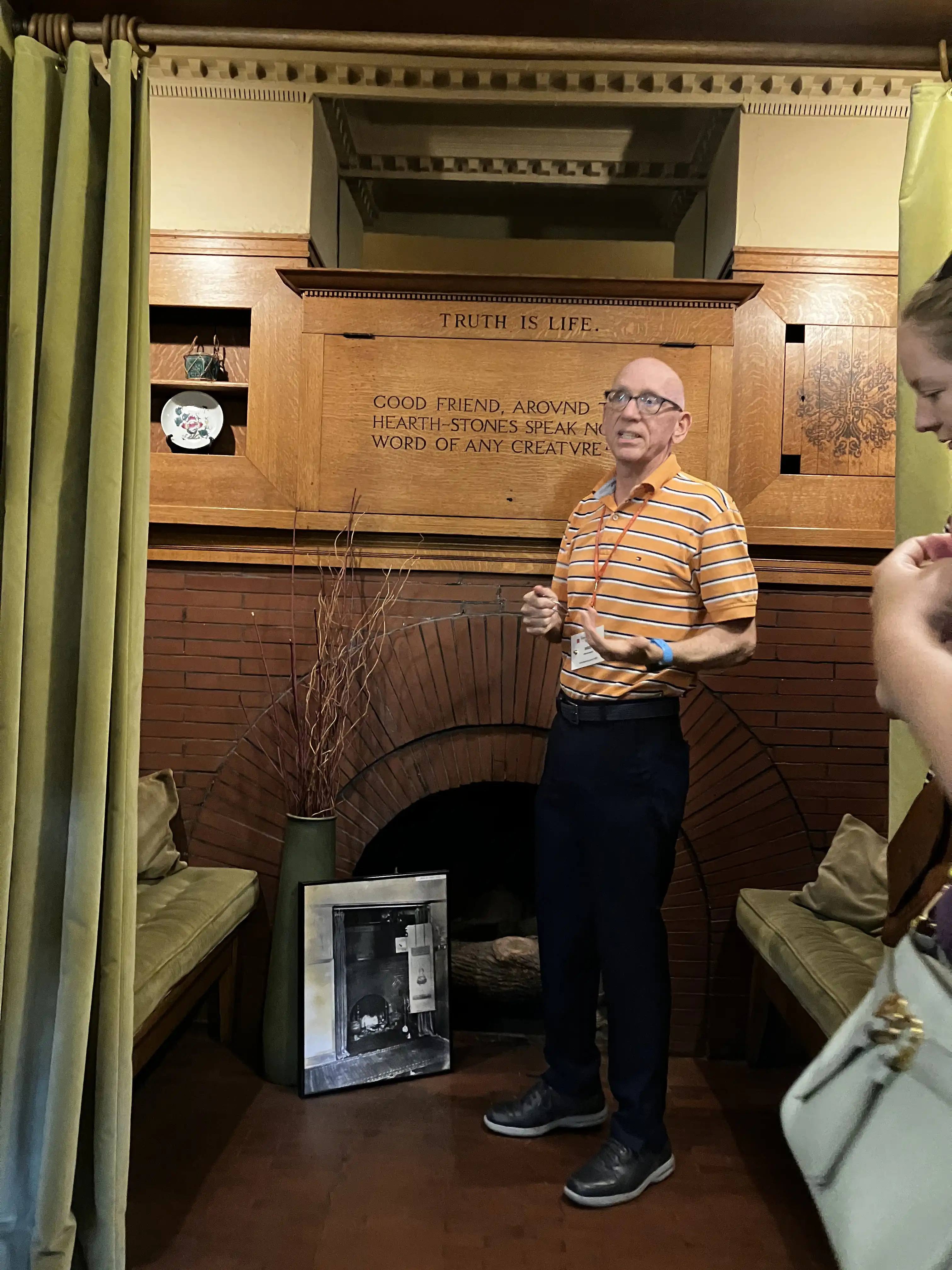 Tour guide explaining the design of Wright's fireplace sitting area.