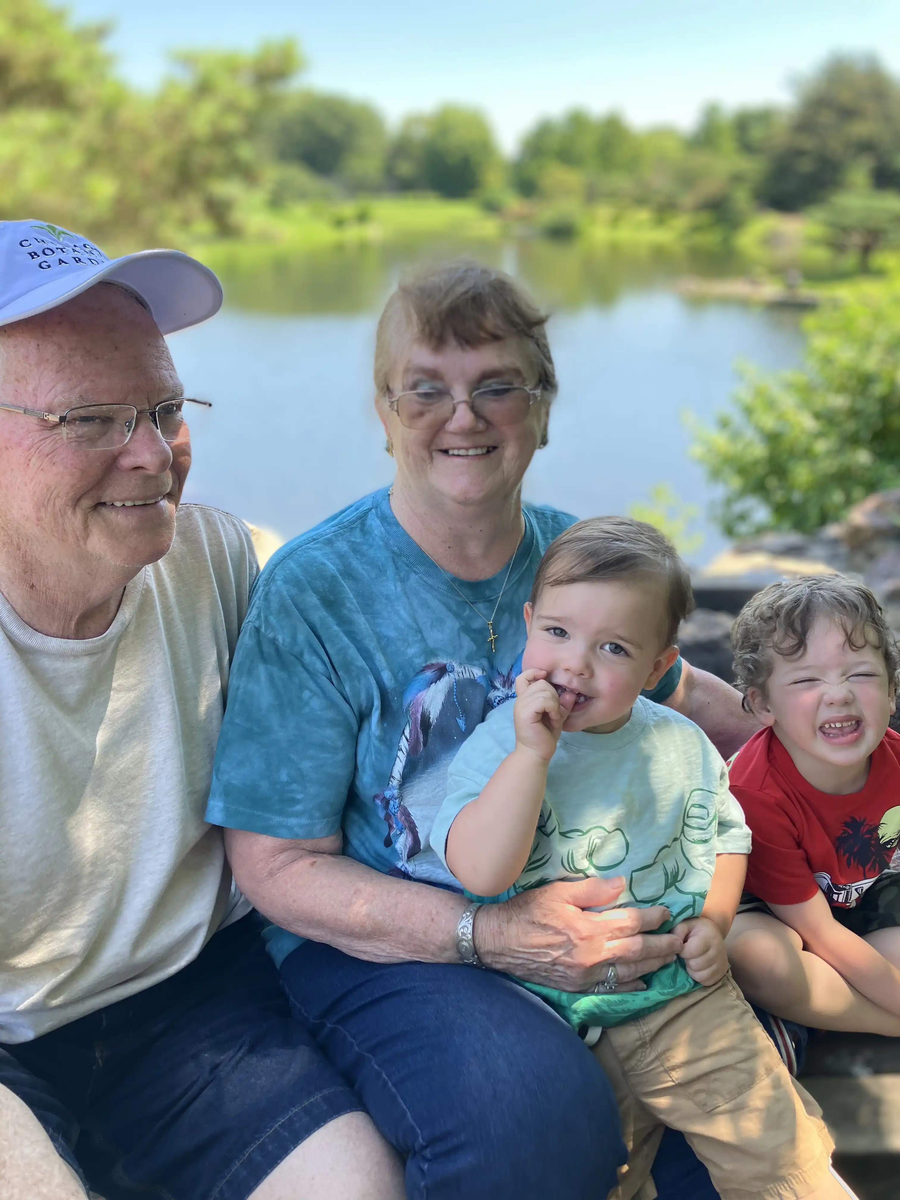 Papaw, Nanny, Graham and Royal with a lake in the background.