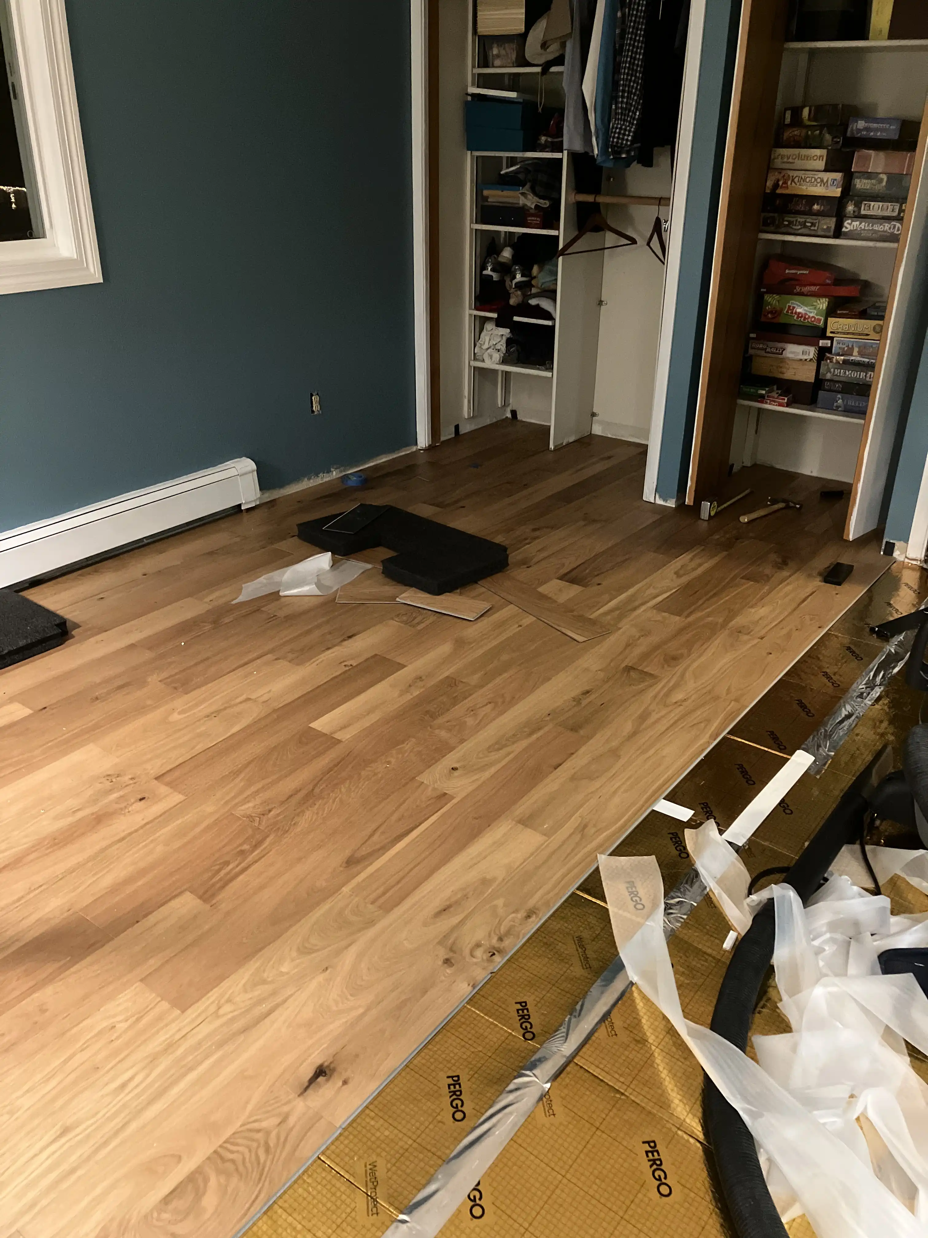 Our bedroom as the engineered hardwood flooring is being laid over the gold underlayment.