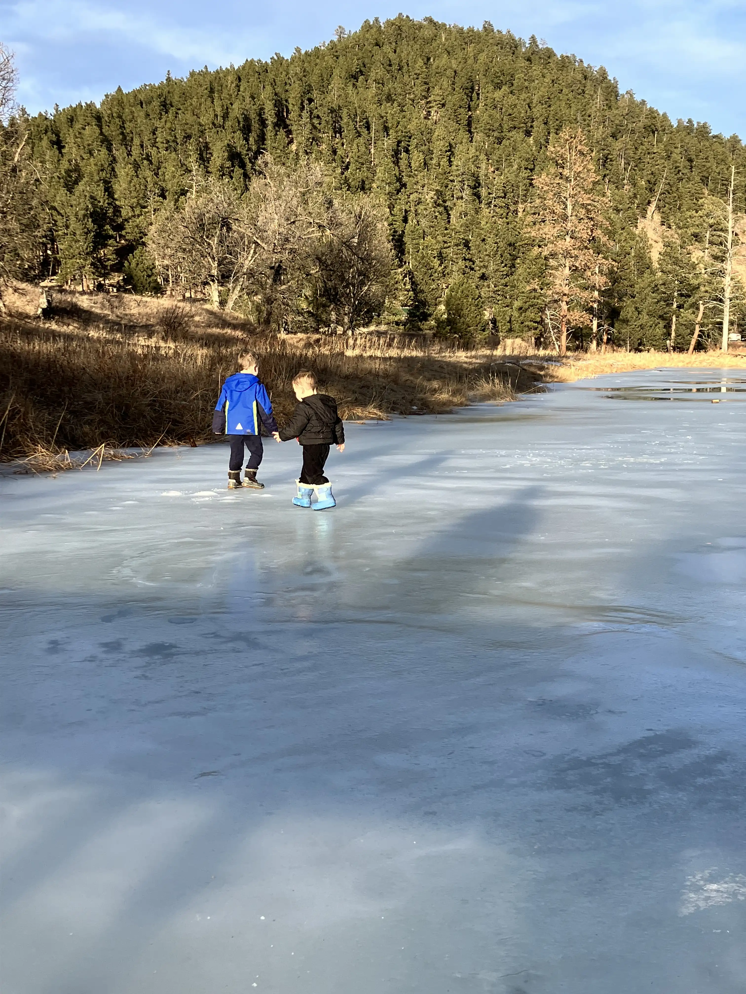 Graham and Royal standing on a frozen river together.