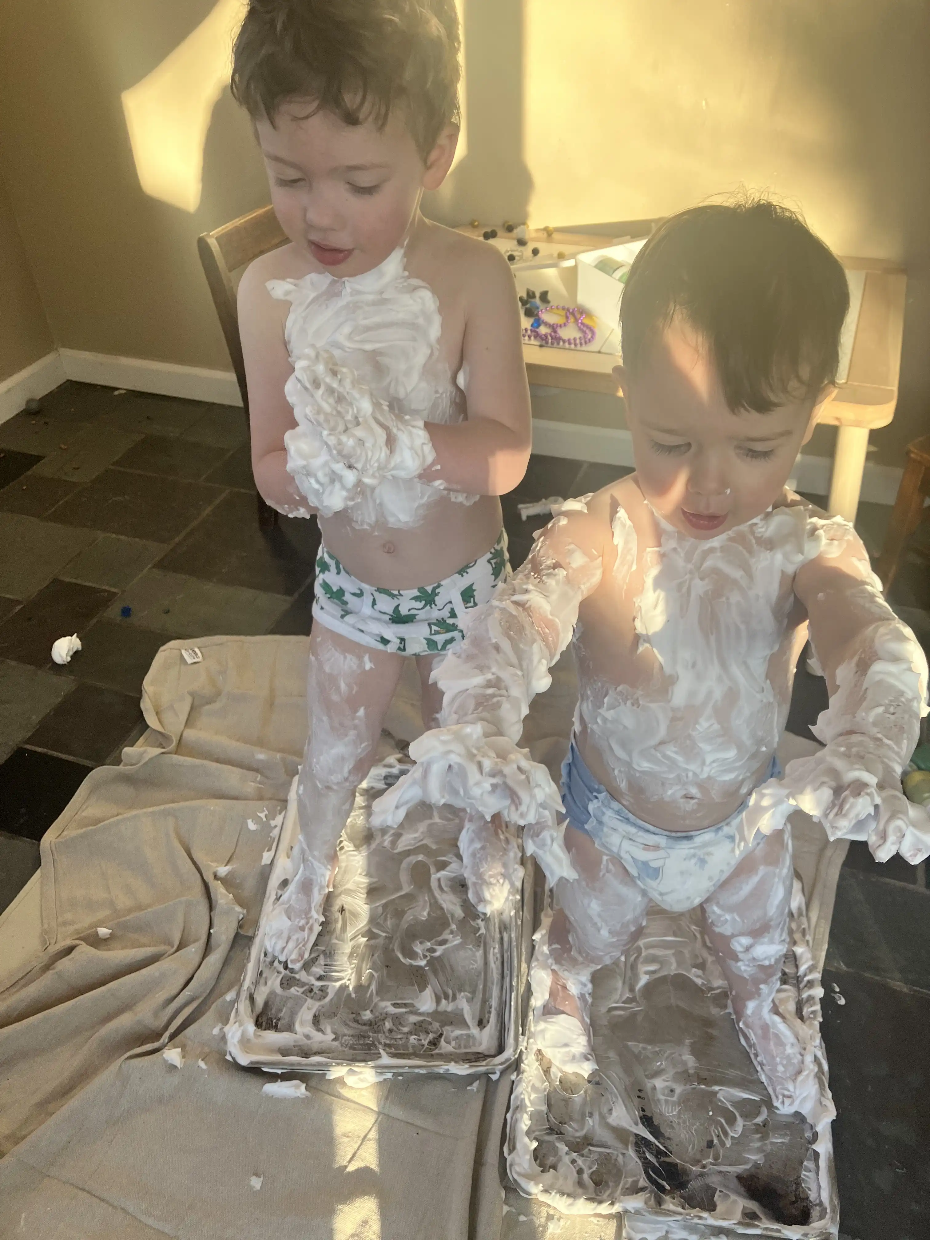 Graham and Royal with their hands raised, covered in shaving cream.