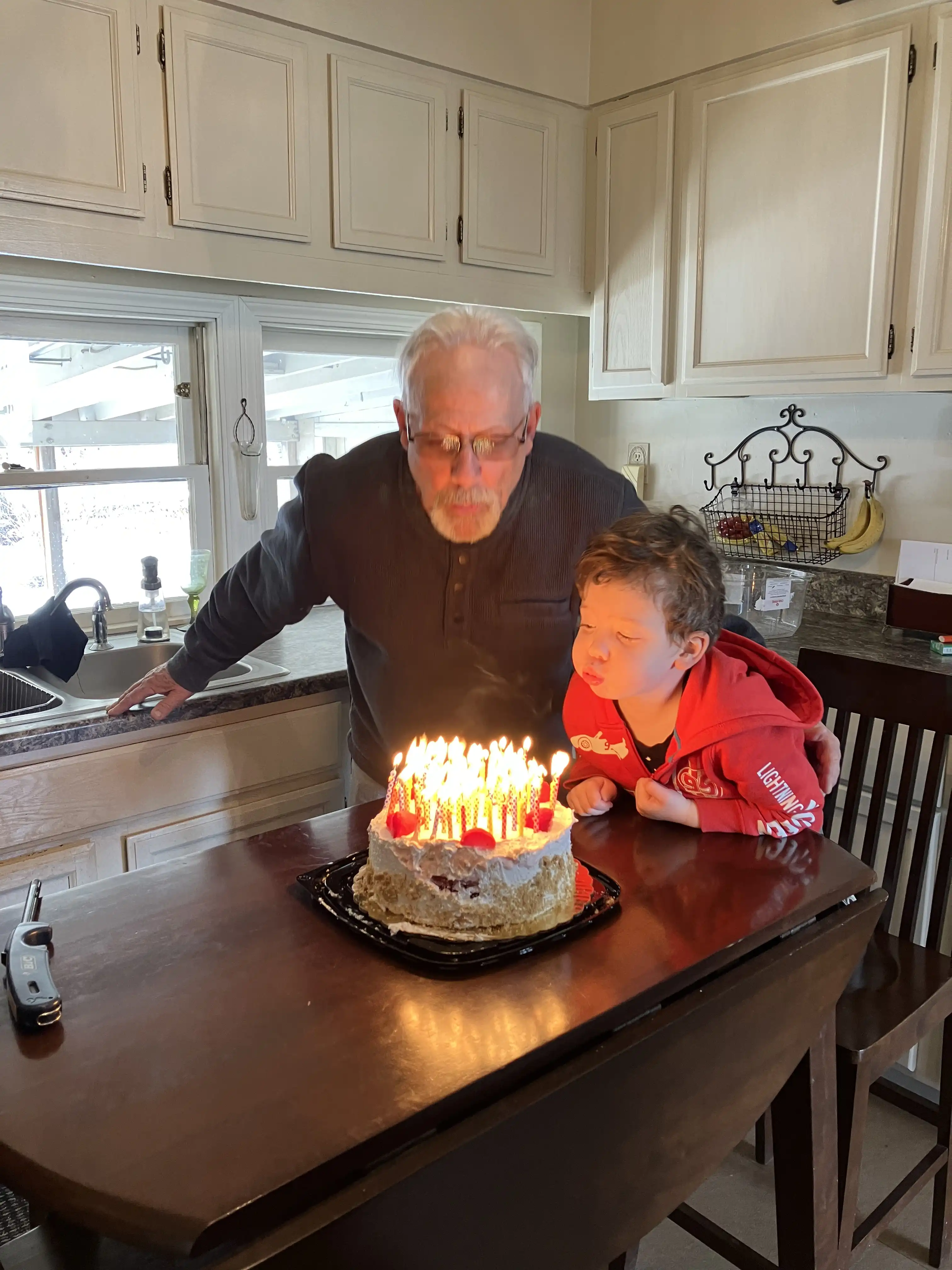 Grandpa and Graham blowing out 70 candles.