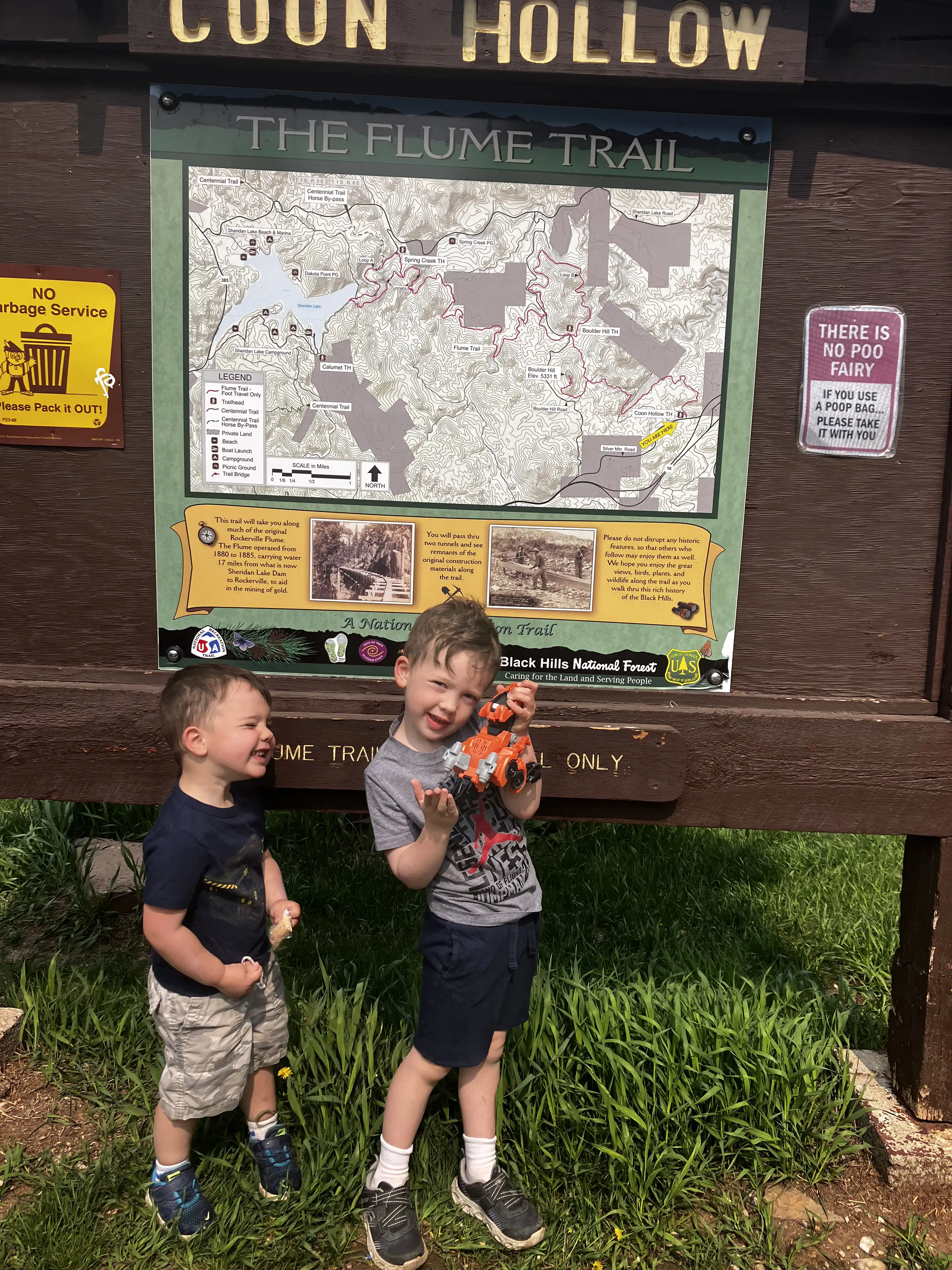Graham and Royal making funny faces in front of a trail sign for Coon Hollow.