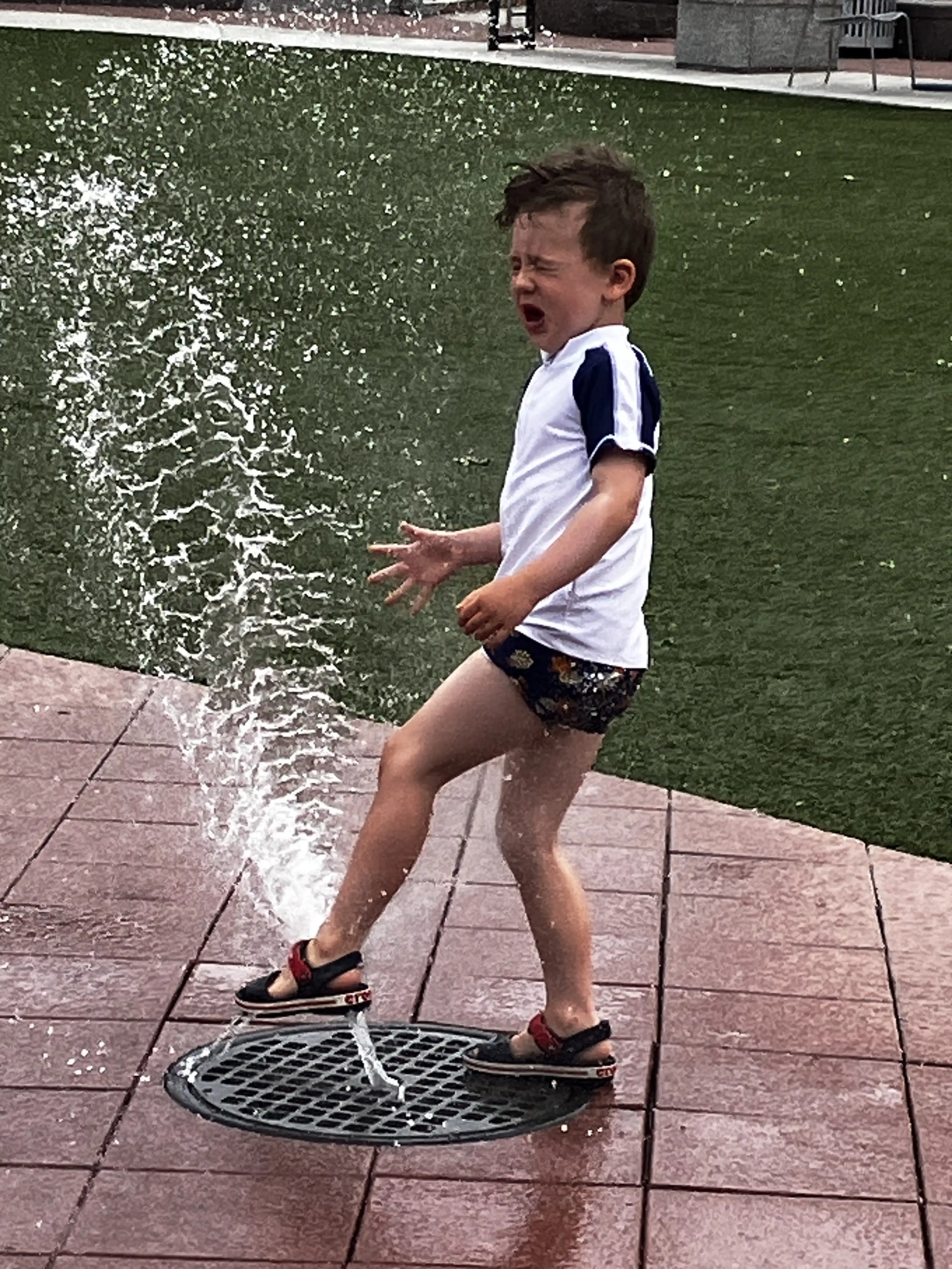Graham wincing at being sprayed by water at a local water park.