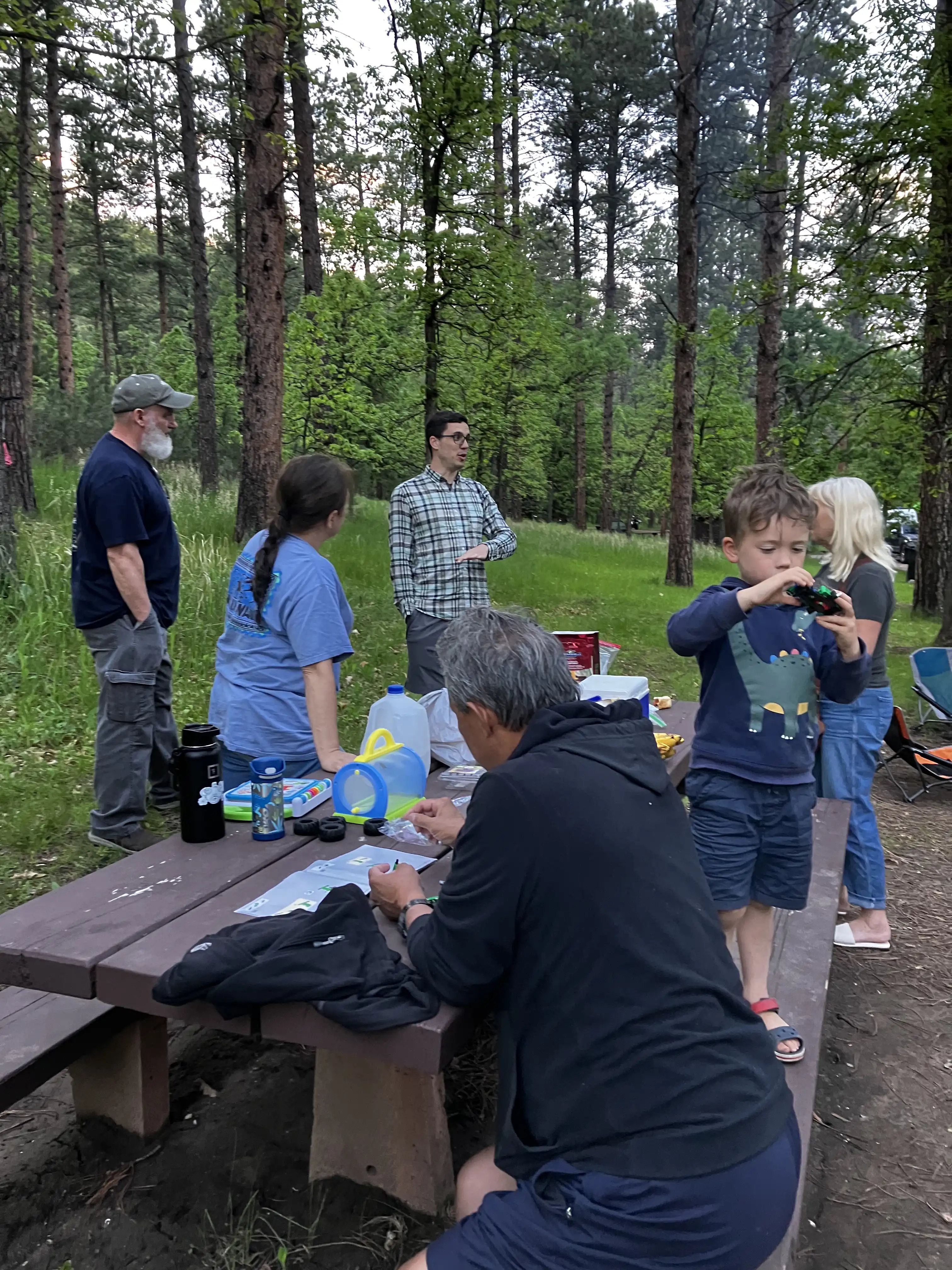 Tommy, Kim, Alex, Gerry, Graham and Jennifer around a picnic table at the campsite.
