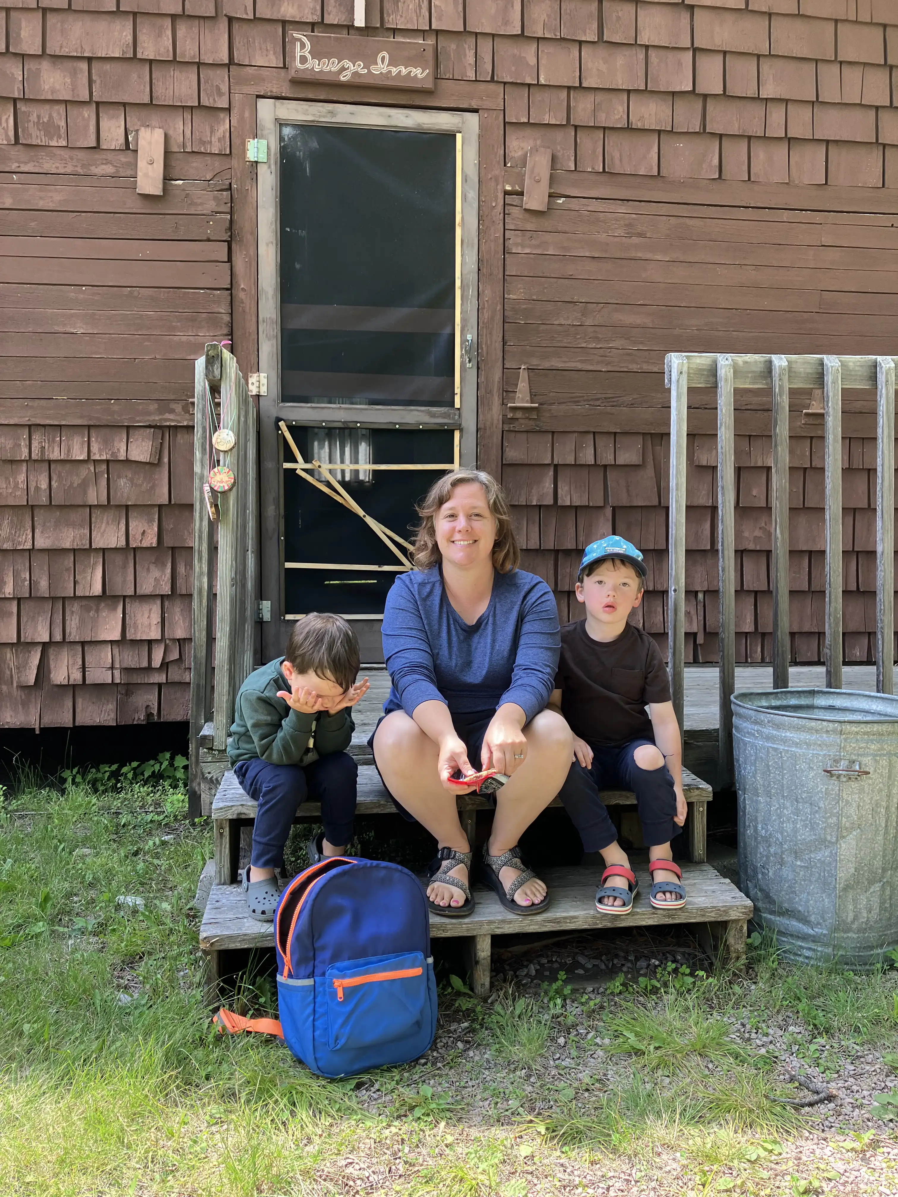 Amie, Graham and Royal seated on the steps outside our cabin.