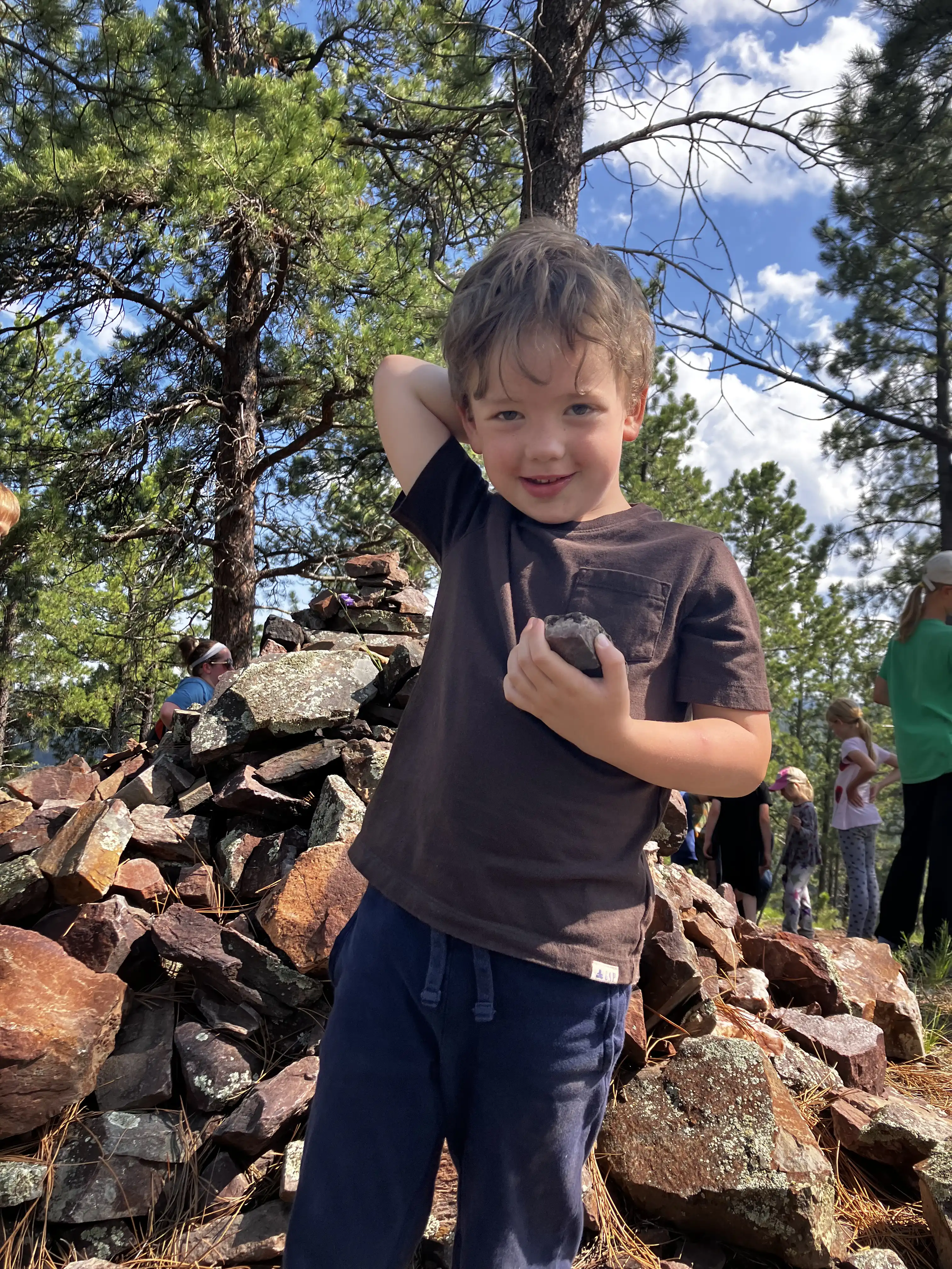 Graham standing in front of the rock memorial at the top of the main Camp Rimrock hike.