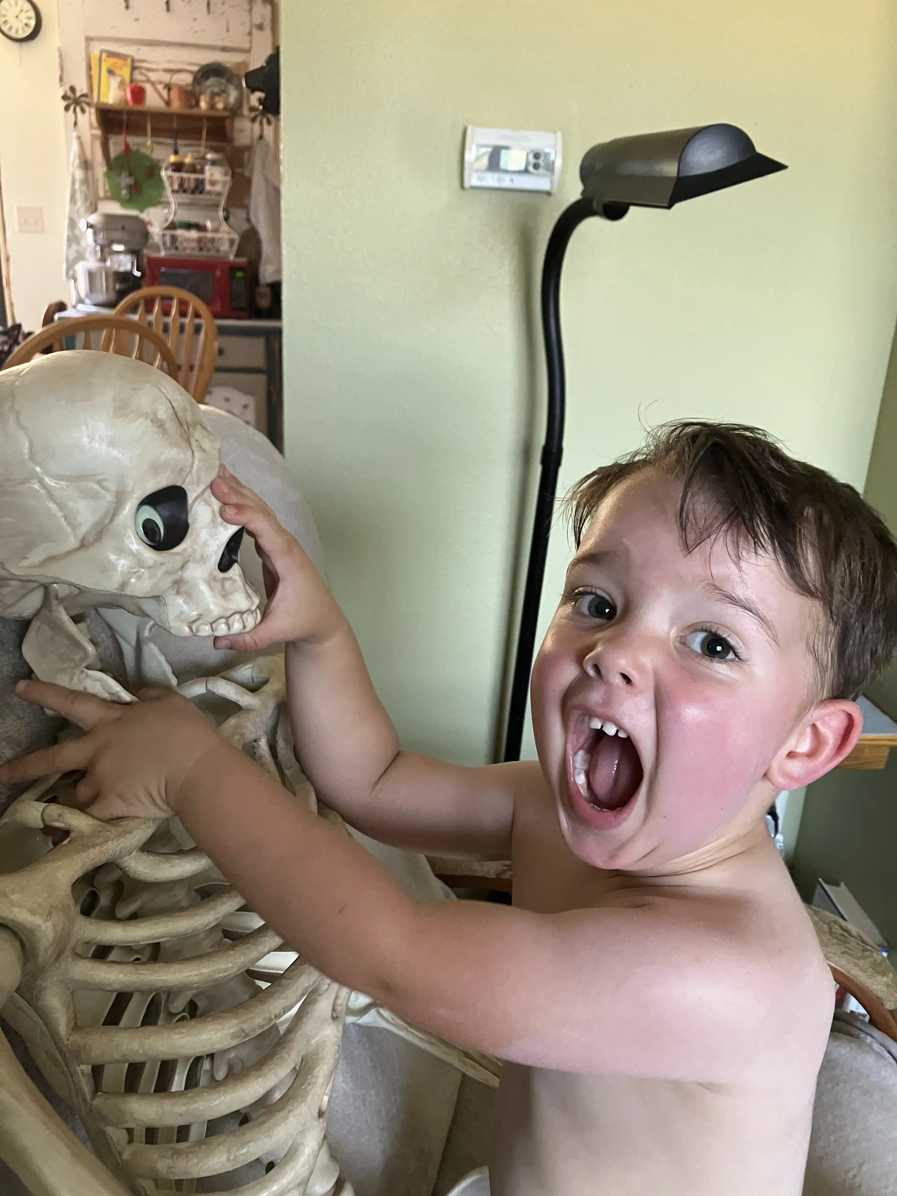 Royal with his mouth open, mimicking the skeleton in whose mouth he has put his hand.