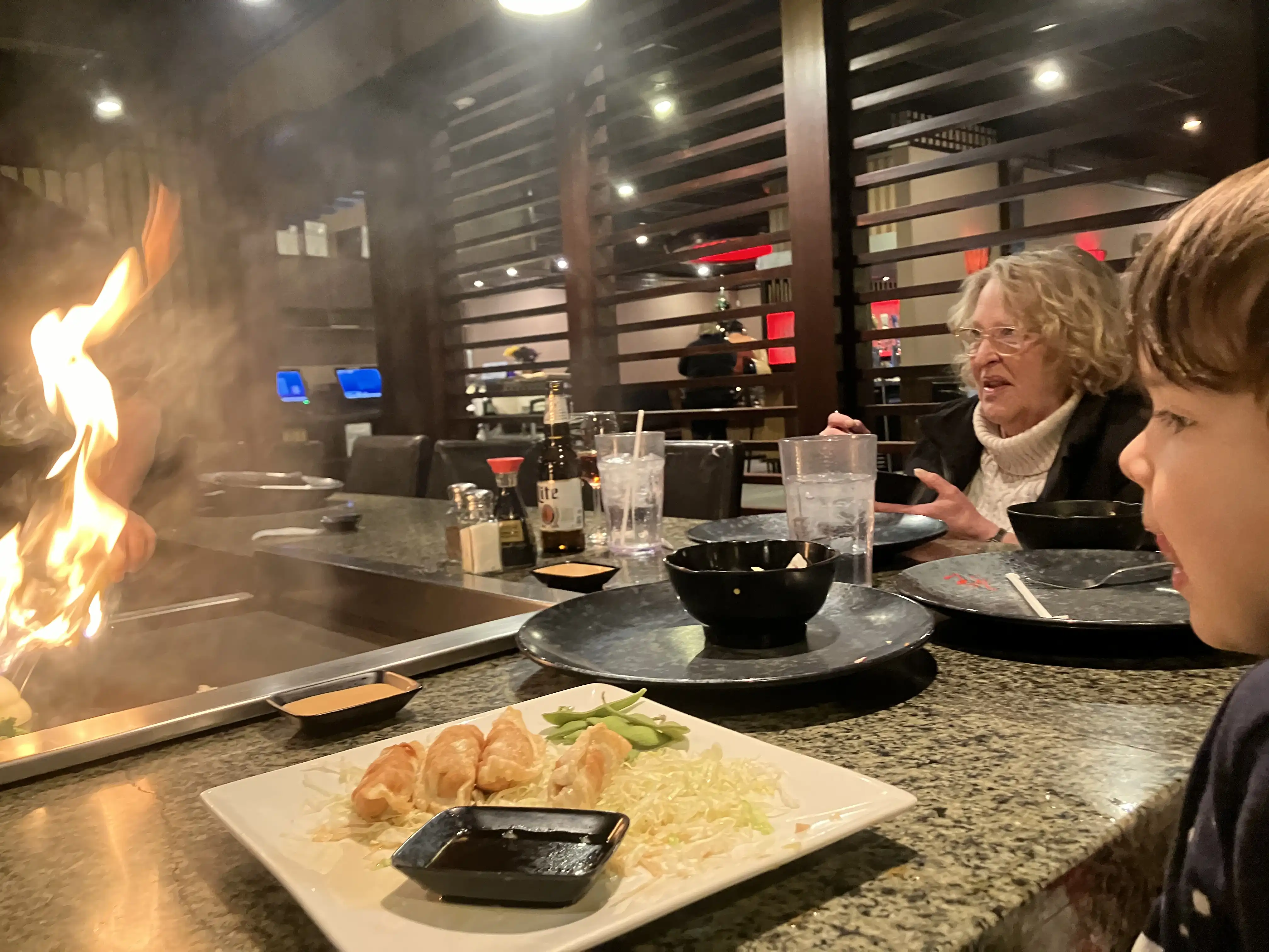 Royal and Grandma Debbie watch the chef light an onion volcano