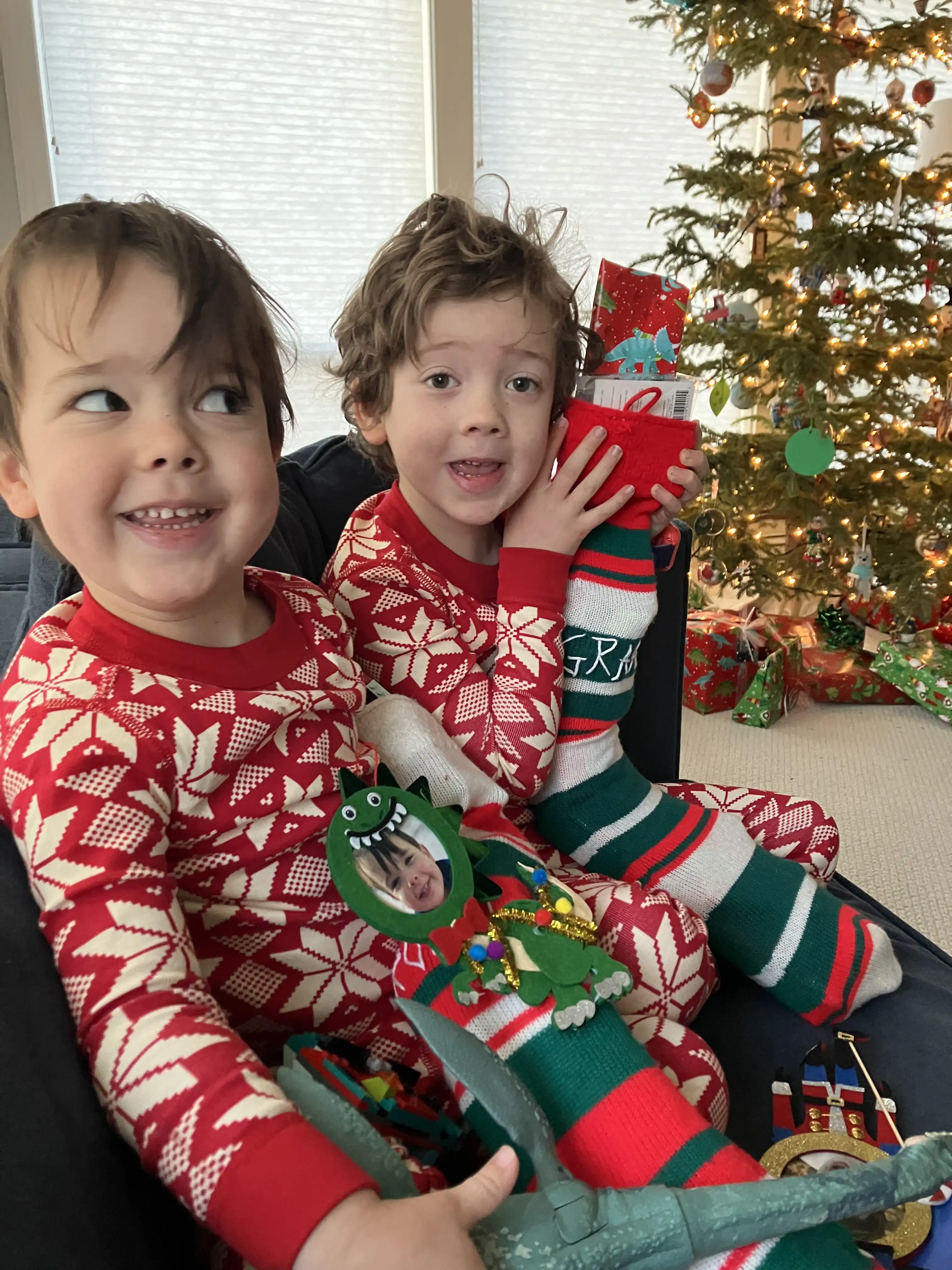 Graham and Royal in matching red-and-white pajamas holding their Christmas stockings