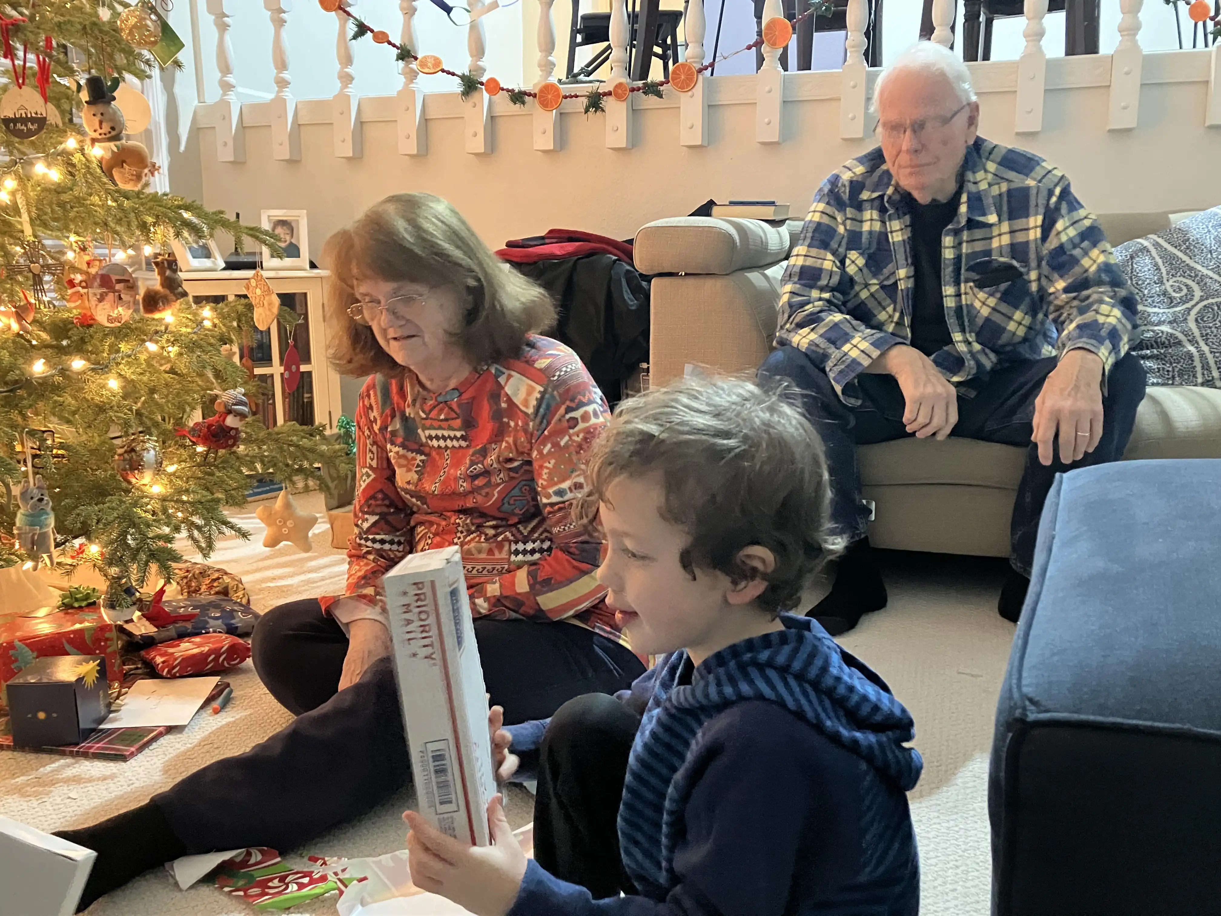 Graham opens a gift with Nanny and Papaw in the background