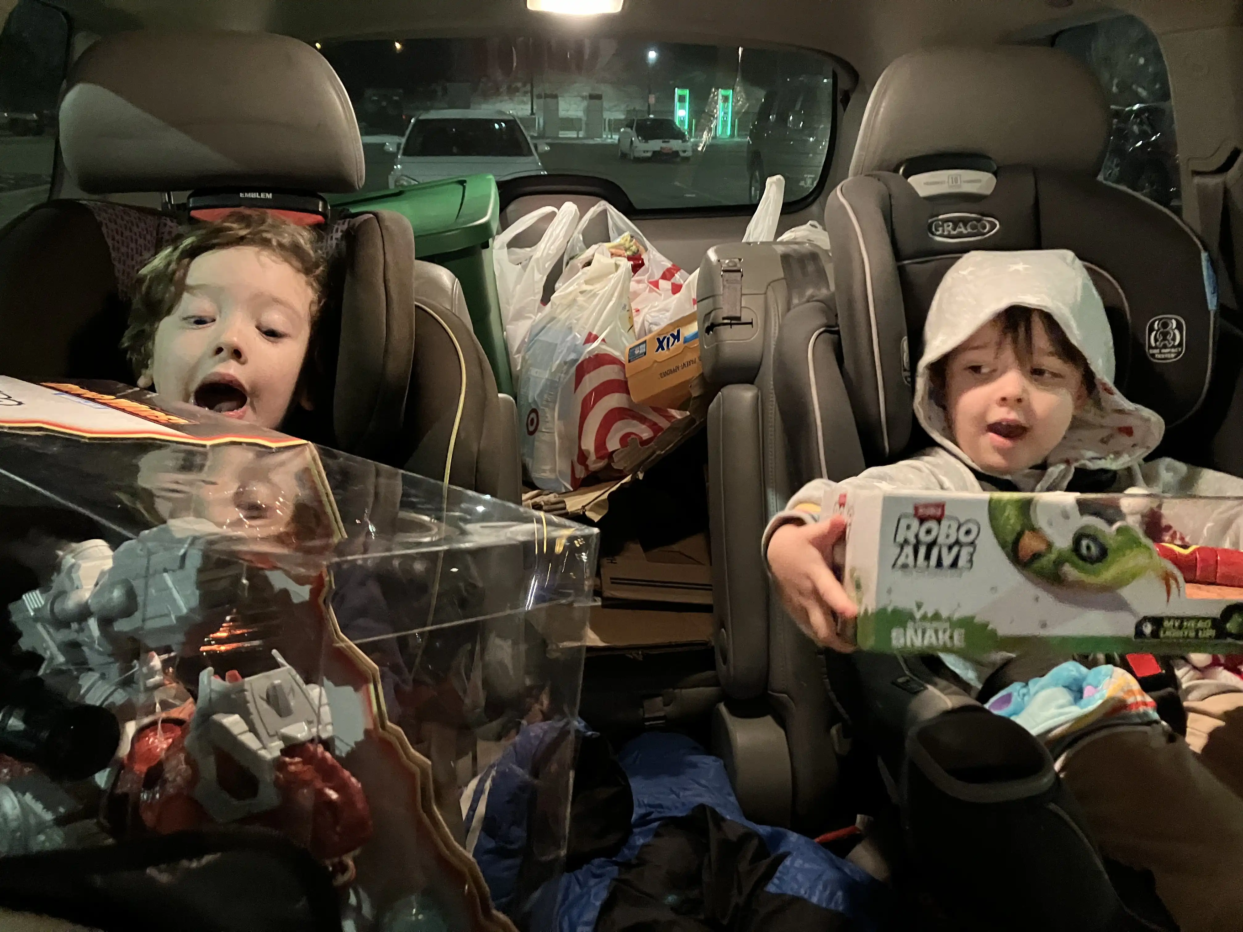 Graham and Royal in their carseats holding their Target toys bought with Christmas money