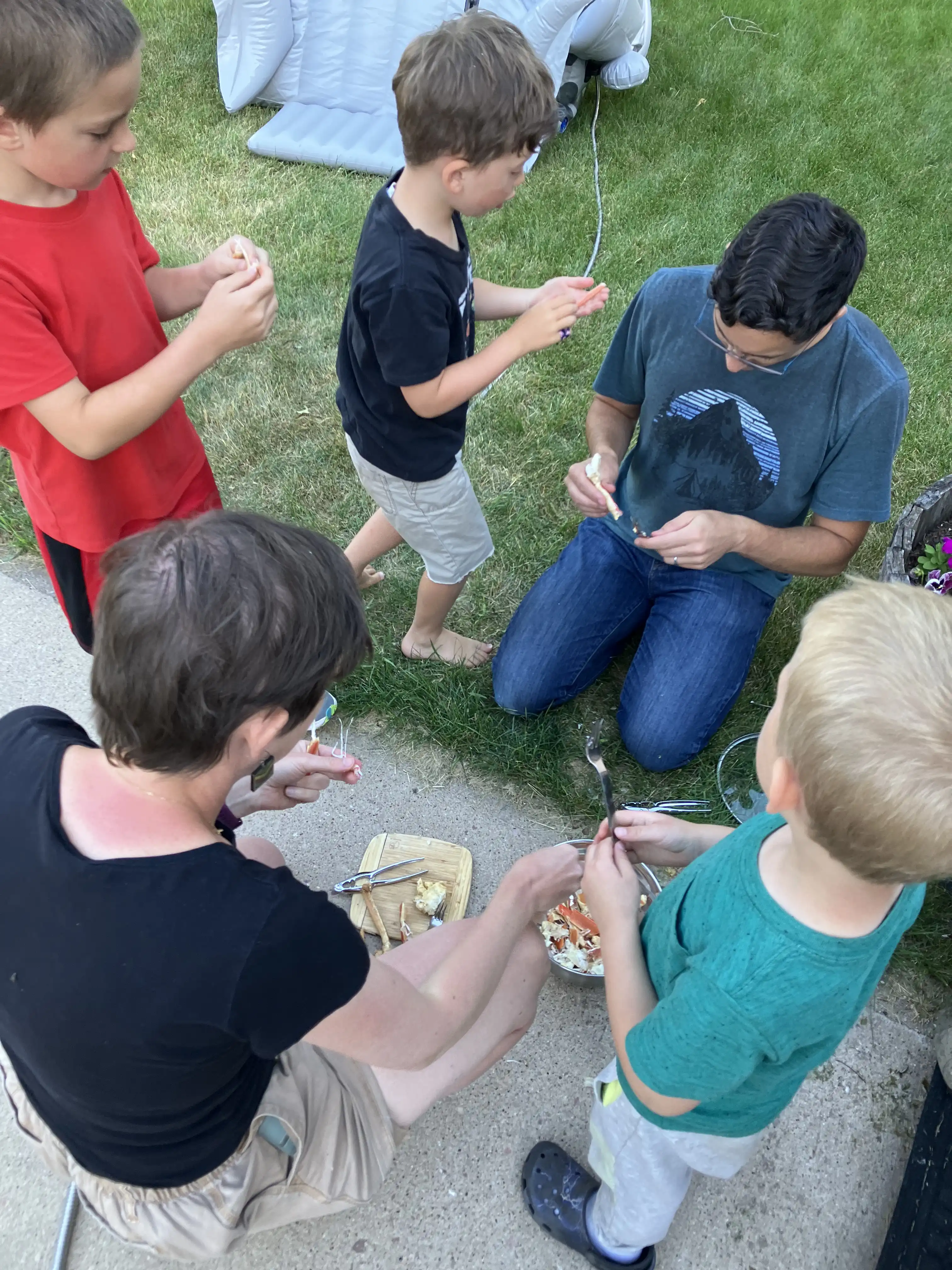 Gabe, Graham, Alex, Natalie and Luke cracking crab legs together.
